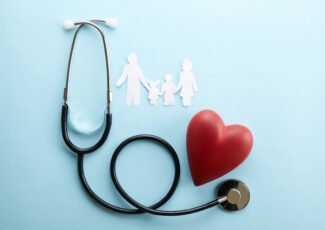 Family health / life insurance concept. Paper chain in form of family, mother, father, son & daughter. Stethoscope acoustic medical device on blue background. Top view, flat lay, copy space, close up